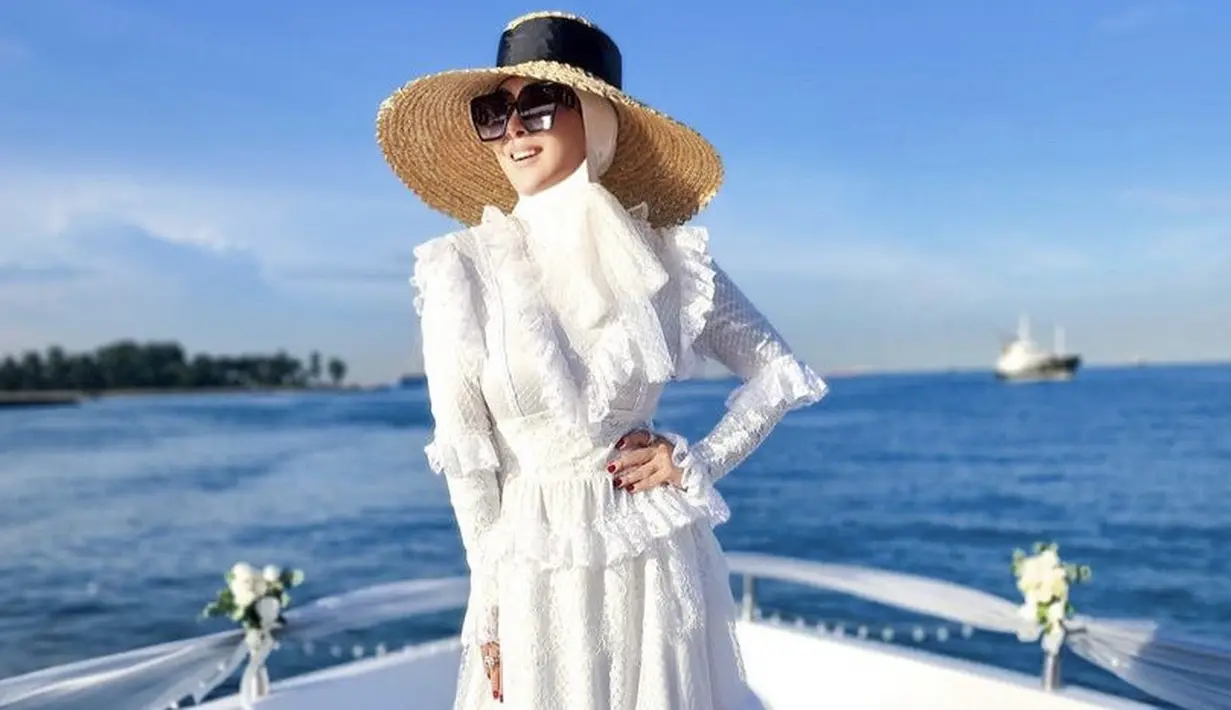 <p>Syahrini tampil glamour dengan dress putih panjang dengan detail ruffle di bagian bawah, dan renda-renda dibagian lengan. Serta pita brokat di bagian depannya. @princessyahrini</p>