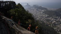 Kru pembersih Brasil melakukan panjat tebing di bawah bayang-bayang salah satu situs paling terkenal di dunia: Patung Kristus Sang Penebus di Rio de Janeiro. (AP Photo/Bruna Prado)