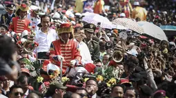 Di atas kereta kuda, Jokowi-JK membuka jas dan dasi serta menggulung kemeja lengan panjang yang dikenakan saat pelantikan, Jakarta, (20/10/14). (Liputan6.com/Faizal Fanani) 