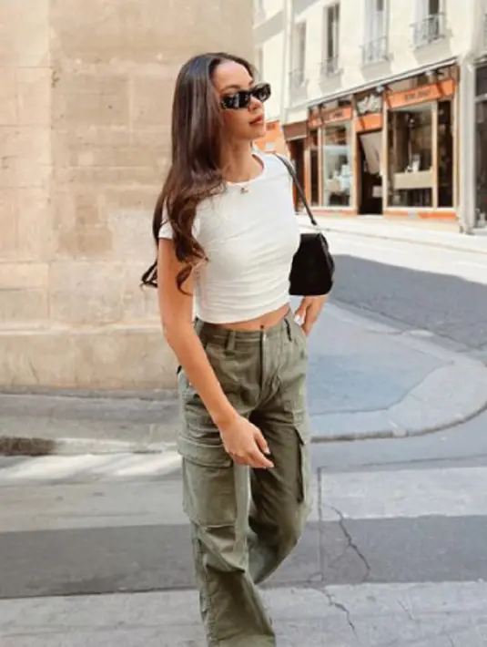 Simple-chic, lihat gaya Alyssa dalam foto ini. Ia mengenakan kaus putih polos yang dipadunya dengan cargo pants berwarna hijau army. Kesan kasual semakin kental dengan mini bag hitam dan sunglasses yang dikenakan Alyssa. Foto: Instagram.