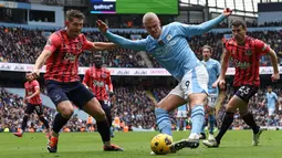 Pemain Manchester City, Erling Haaland, berusaha melepaskan diri dari adangan pemain Everton pada laga Premier League 2023/2024 pekan 24 di Stadion Etihad, Sabtu (10/2/2024). (AFP/Darren Staples)