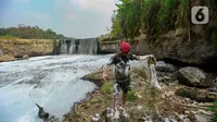 Warga merapikan jala ikan di sungai yang tercemar limbah pabrik di kawasan Angsana, Gunung Putri, Bogor, Minggu (27/08/2023). (merdeka.com/Arie Basuki)