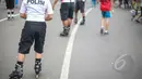 Sejumlah polisi berpatroli dengan memakai sepatu roda di area Car Free Day, di Bundaran HI, Jakarta, Minggu (3/5/2015). Tampak para polisi mengenakan seragam khusus kemeja yang didominasi warna putih-biru dan celana selutut. (Liputan6.com/Faizal Fanani) 
