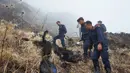 Petugas memeriksa jasad tubuh yang terbakar di dekat jatuhnya pesawat Twin Otter milik maskapai Tara Air di pegunungan Nepal, Rabu (24/2). Di sekitar puing pesawat juga ditemukan potongan tubuh yang diduga milik para penumpang. (REUTERS/Santosh Gautam)