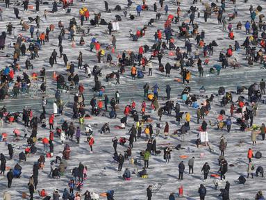 Peserta saat mengikuti lomba memancing ikan trout di sungai yang membeku di Hwacheon, Korea Selatan (6/1). Kontes ini merupakan bagian dari festival es tahunan yang menghasilkan lebih dari 1.000.000 pengunjung setiap tahunnya. (AP Photo/Ahn Young-joon)