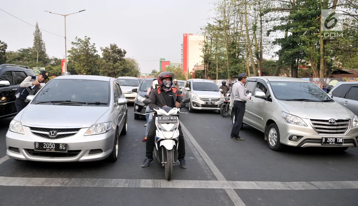Petugas Dinas Perhubungan DKI Jakarta melakukan sosialisasi uji coba perluasan sistem ganjil genap kepada pengendara di kawasan Pramuka, Jakarta, Senin (12/8/2019). Dinas Perhubungan DKI Jakarta melakukan uji coba perluasan sistem ganjil genap hingga 6 September 2019. (merdeka.com/Iqbal Nugroho)