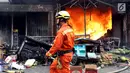 Petugas pemadam kebakaran melintas di depan ruko yang terbakar di Pasar Kebayoran Lama, Jakarta, Selasa (13/6). Kebakaran yang melanda ruko tersebut belum diketahui penyebabnya. (Liputan6.com/Johan Tallo)
