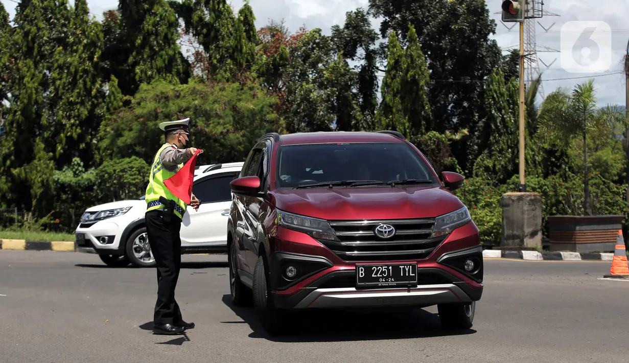<p>Polisi mengarahkan kendaraan saat melakukan sistem buka tutup jalan menuju Pelabuhan Merak, Cilegon, Banten, Jumat (29/4/2022). Sistem buka tutup tersebut membuat kemacetan panjang hingga ke dalam Tol Tangerang-Merak. (Liputan6.com/Angga Yuniar)</p>