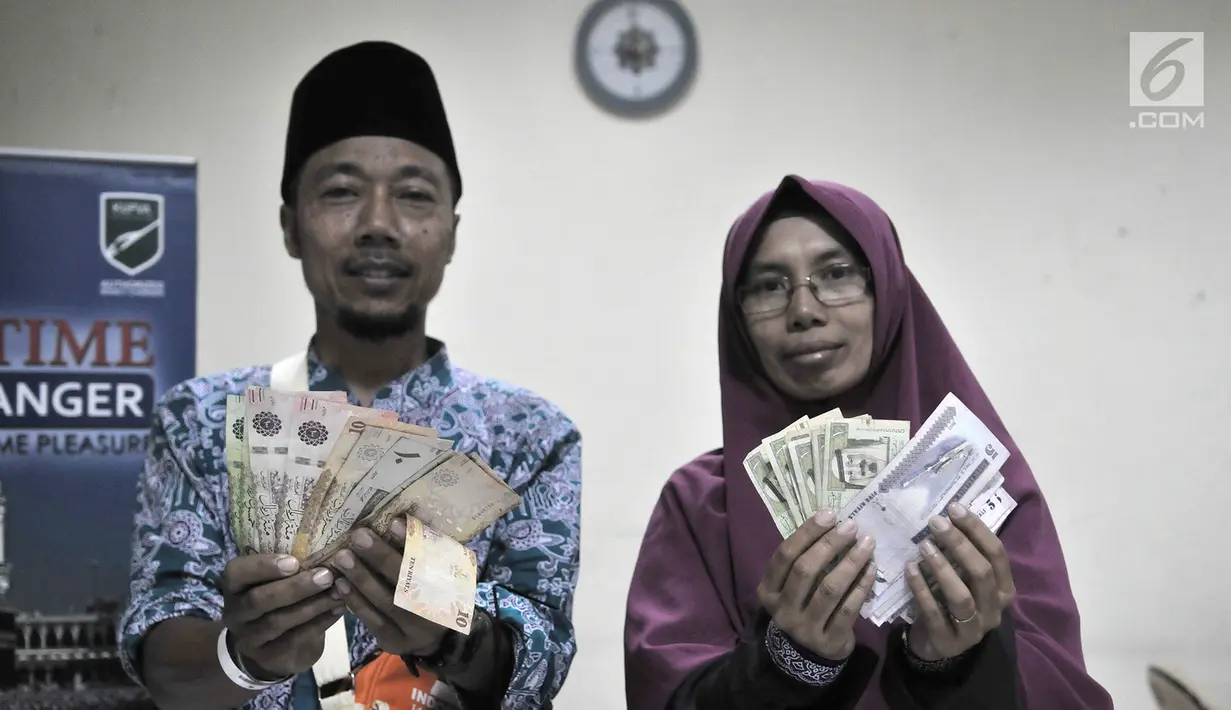 Calon jemaah haji menunjukkan  mata uang riyal di Asrama Haji Pondok Gede, Jakarta, Senin (22/7/2019). Nilai tukar untuk pecahan 100 dan 500 riyal dibanderol Rp 3.755 per satu riyal. (merdeka.com/Iqbal Nugroho)