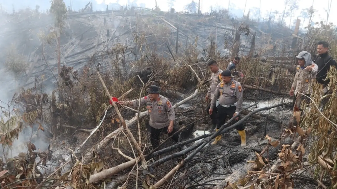 Polisi di Indragiri Hulu mendinginkan lokasi kebakaran lahan yang sudah padam agar api tidak muncul lagi.