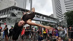  'Pole Dance' yang memiliki cap sebagai tarian erotis diperkenalkan sebagai alternatif latihan fisik untuk menjaga kebugaran tubuh dan kekuatan otot, Bundaran HI, Jakarta, Minggu (18/1/2015). (Liputan6.com/Miftahul Hayat)