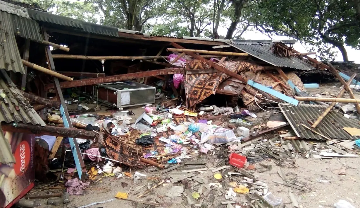 Puing-puing terlihat dari rumah yang rusak setelah tsunami menerjang Pantai Carita, di perairan Banten, Minggu (23/12). Tsunami menerjang beberapa daerah di sekitar Selat Sunda pada Sabtu 22 Desember 2018 malam. (SEMI / AFP)