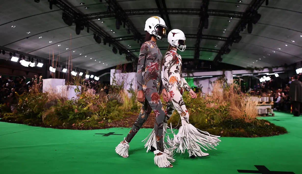 Model berjalan di atas catwalk mengenakan rancangan koleksi Fall/Winter 2019 dari brand Off-White di Paris Fashion Week, Rabu (16/1). Dalam perhelatan itu, sejumlah model mengenakan helm futbol, saat melenggang di catwalk. (Anne-Christine POUJOULAT / AFP)