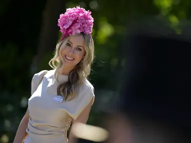 Naomi Rees mengenakan topi bunga berpose setelah tiba untuk hari pertama acara balap kuda Royal Ascot, di Ascot Racecourse, di Ascot, Inggris, Selasa (14/6/2022). (AP Photo/Alastair Grant)