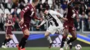 Gelandang Juventus, Federico Bernardeschi, berebut bola dengan bek Torino, Meite Soualiho, pada laga Serie A di Stadion Allianz, Turin, Jumat (3/5). Kedua klub bermain imbang 1-1. (AFP/Marco Bertorello)