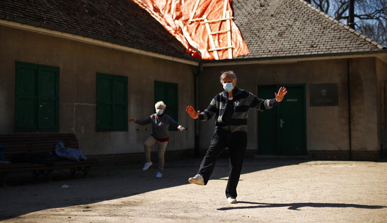 Orang-orang mengenakan masker untuk mencegah penyebaran COVID-19 saat berlatih Tai Chi di Taman Cinquantenaire, Brussel, Belgia, Senin (29/3/2021). Pemerintah Belgia akan menutup sekolah dan membatasi akses warga ke bisnis yang tidak penting selama lockdown ketat COVID-19. (AP Photo/Francisco Seco)