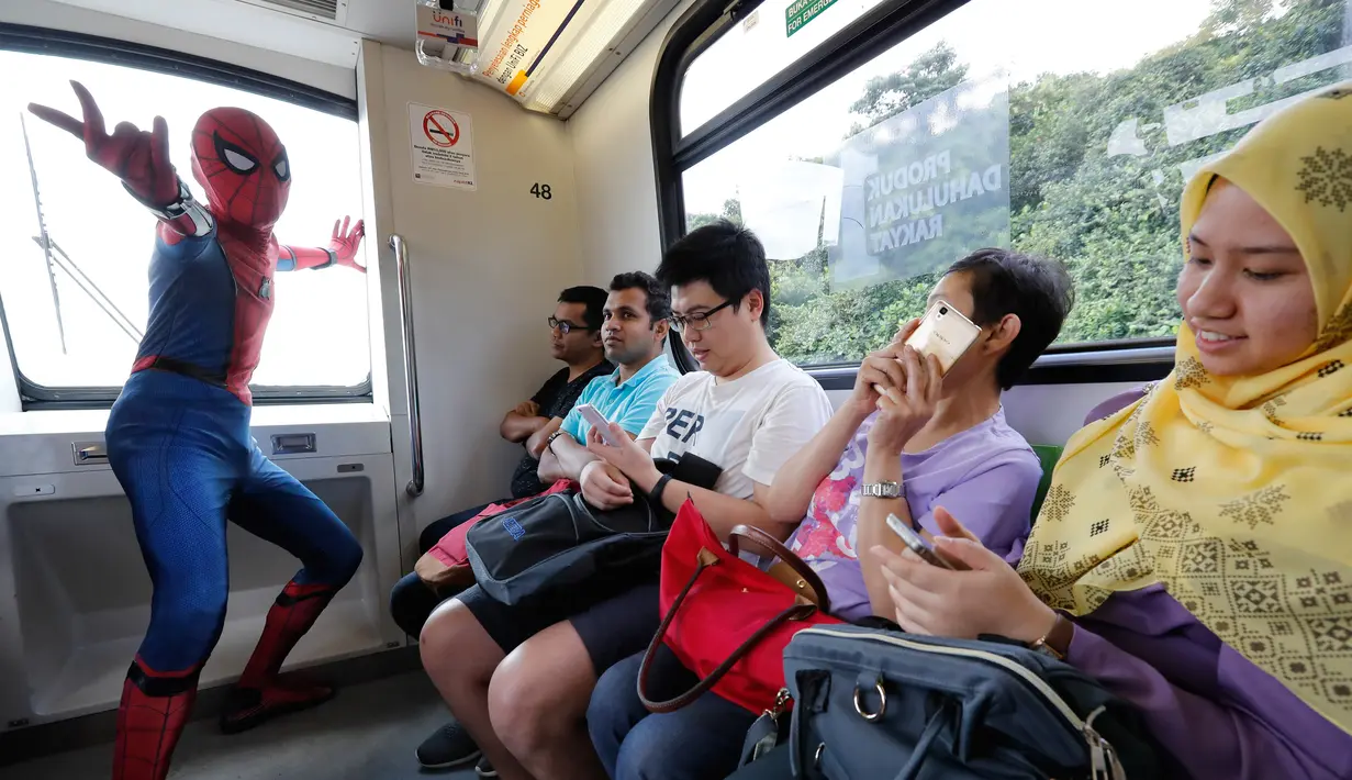 Seorang cosplayer berkostum Spider-Man berpose di dalam Light Rail Transit saat acara cosplay di Kuala Lumpur, Malaysia, Sabtu, 8 Juli 2017. Sejumlah tokoh karakter animasi tiba-tiba muncul di tengah-tengah ruang publik. (AP Photo/Vincent Thian)