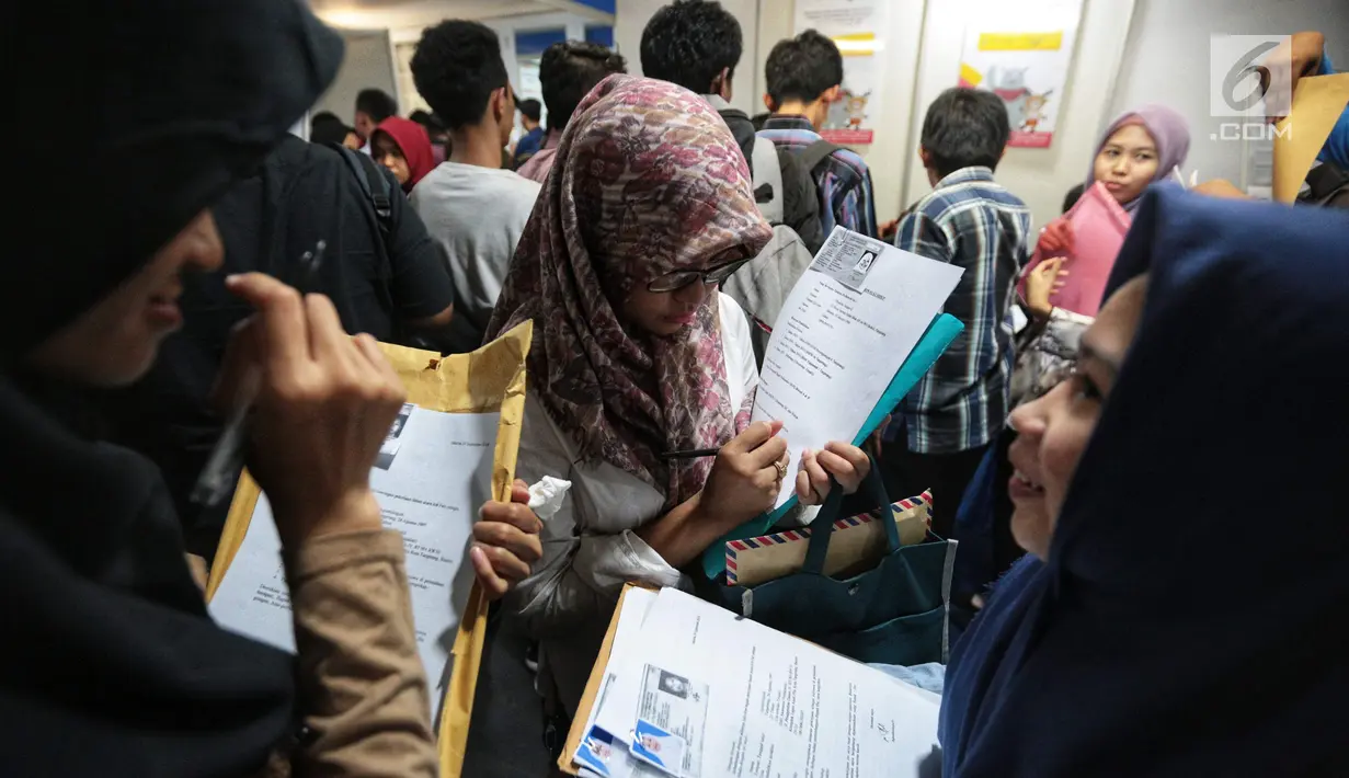 Pencari kerja menyiapkan dokumen saat Job Fair di Istora GBK, Jakarta, Rabu (19/9). Job Fair bertajuk Jakarta spektakuler "Job for Career" diikuti lebih dari 120 perusahaan BUMN, swasta skala nasional maupun internasional. (Liputan6.com/Faizal Fanani)