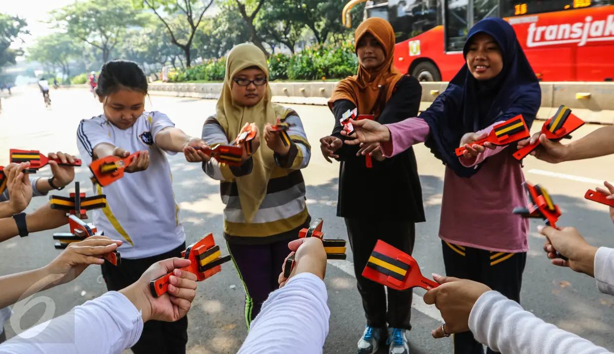 Sejumlah anak muda yang tergabung dalam komunitas Hyakka Ryouran membentuk lingkaran dengan alat musik asal Jepang, Naruko, di kawasan Senayan, Jakarta, Minggu (24/7). Naruko dipergunakan saat mengiringi Tarian Yosakoi. (Liputan6.com/Fery Pradolo)