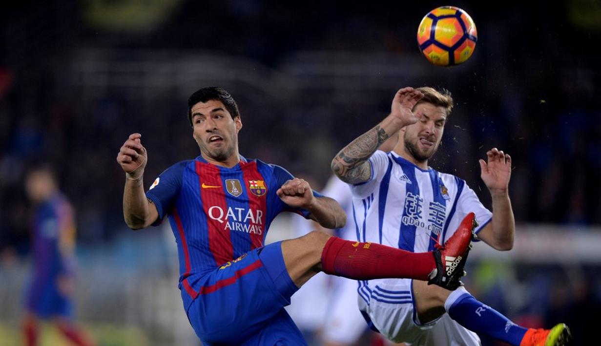 Striker Barcelona, Luis Suarez, berebut bola dengan pemain Real Sociedad, Inigo Martinez, pada pekan ke-13 La Liga Spanyol di Estadio Municipal de Anoeta, Minggu (27/11/2016). (Reuters/Vincent West)