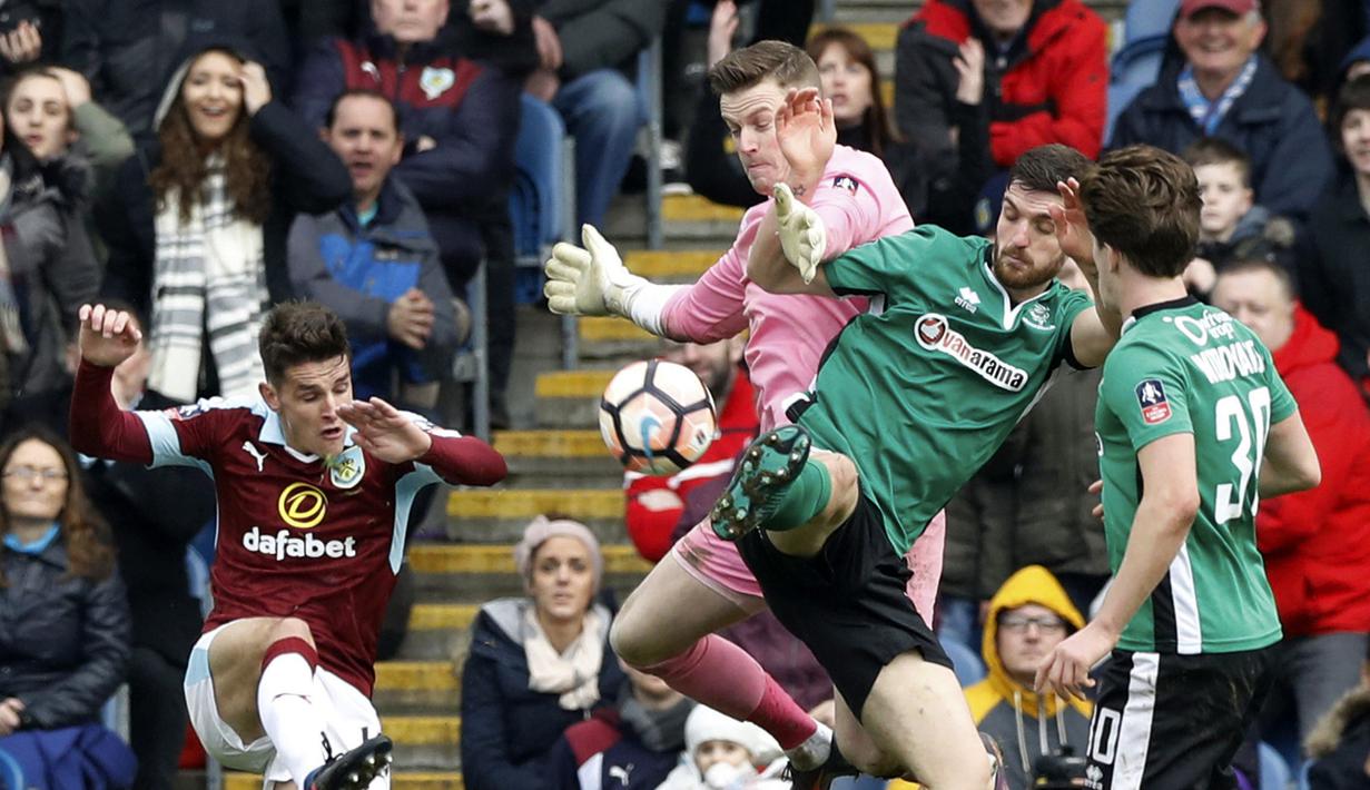 Pemain Burnley, Ashley Westwood (kiri) melakukan tembakan yang dihadang para pemain Lincoln City FC pada babak kelima Piala FA di Turf Moor, Sabtu (18/2/2017). Lincoln FC lolos ke perempat-final dengan skor 1-0. (Martin Rickett/PA via AP)