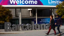 Orang-orang berjalan melewati poster yang mengumumkan Mobile World Congress (MWC) 2020 di lokasi pameran di Barcelona, Spanyol, Selasa (11/2/2020). Pembatalan MWC 2020 dilakukan setelah diadakannya pertemuan darurat oleh para petinggi penyelenggara. (AP Photo/Emilio Morenatti)