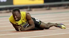 Pelari asal Jamaika, Usain Bolt terkapar di lintasan setelah terjatuh dan cedera di final 4x100 meter pada Kejuaraan Dunia Atletik di London, Sabtu (12/8). Bolt sempat tertatih-tatih sebelum akhirnya jatuh dan gagal melanjutkan lomba. (AP/Tim Ireland)