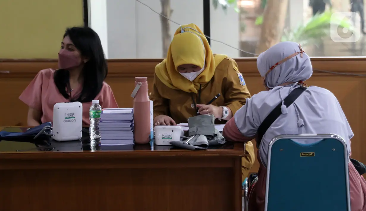 Petugas kesehatan mendata warga yang menjalani vaksinasi booster kedua atau dosis keempat di kawasan Kantor Wali Kota Jakarta Timur, Jakarta, Selasa (24/1/2023). Dimulainya vaksinasi booster kedua juga berdasarkan rekomendasi Komite Ahli Penasihat Ahli Imunisasi Nasional (IndonesiaTechnical Advisory Group on Immunization/ITAGI). (Liputan6.com/Johan Tallo)