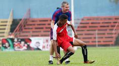 Legenda Manchester United, Denis Irwin (kanan) membantu pemain yang terjatuh pada acara United Way Coaching Clinic You C 1000 di Stadion Soemantri Brojonegoro, Jakarta, Sabtu (7/5/2016). (Bola.com/Nicklas Hanoatubun)