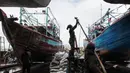 Buruh melakukan perbaikan kapal nelayan di Galangan kapal, Muara Angke, Jakarta, Minggu (23/12/2020). Dimasa pandemi Covid 19 aktivitas di galangan kapal tetap berjalan normal seperti biasa. (Liputan6.com/Angga Yuniar)