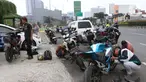 Pengendara motor mencopot knalpot bising usai terjaring razia yang digelar Satlantas PolresMetro Depok di Jalan Margonda Raya, Depok, Kamis (18/3/2021). Puluhan motor berknalpot bising yang terjaring razia diwajibkan mengganti knalpot dan diberi sanksi tilang. (Liputan6.com/Helmi Fithriansyah)