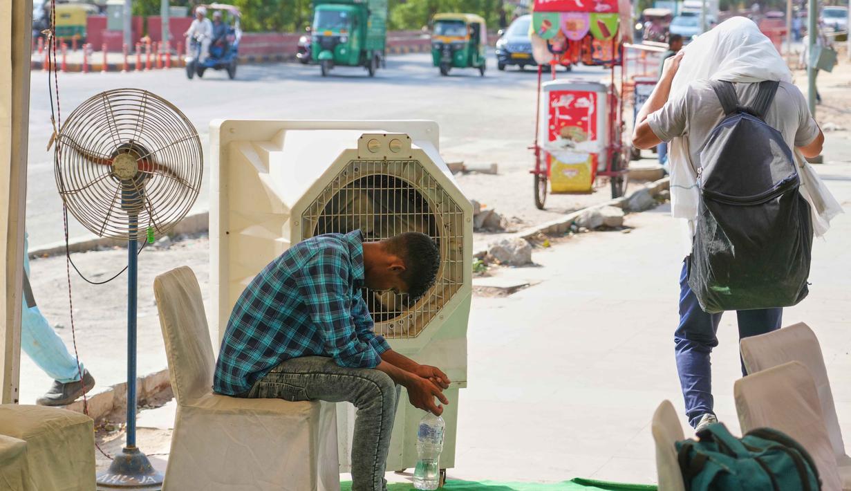 Seorang pria duduk di depan pendingin air di stasiun pendingin pinggir jalan yang didirikan oleh pemerintah untuk memberikan bantuan bagi masyarakat dari panas terik musim panas di New Delhi, India, Rabu 20 Mei 2026. (AP Photo/Manish Swarup)