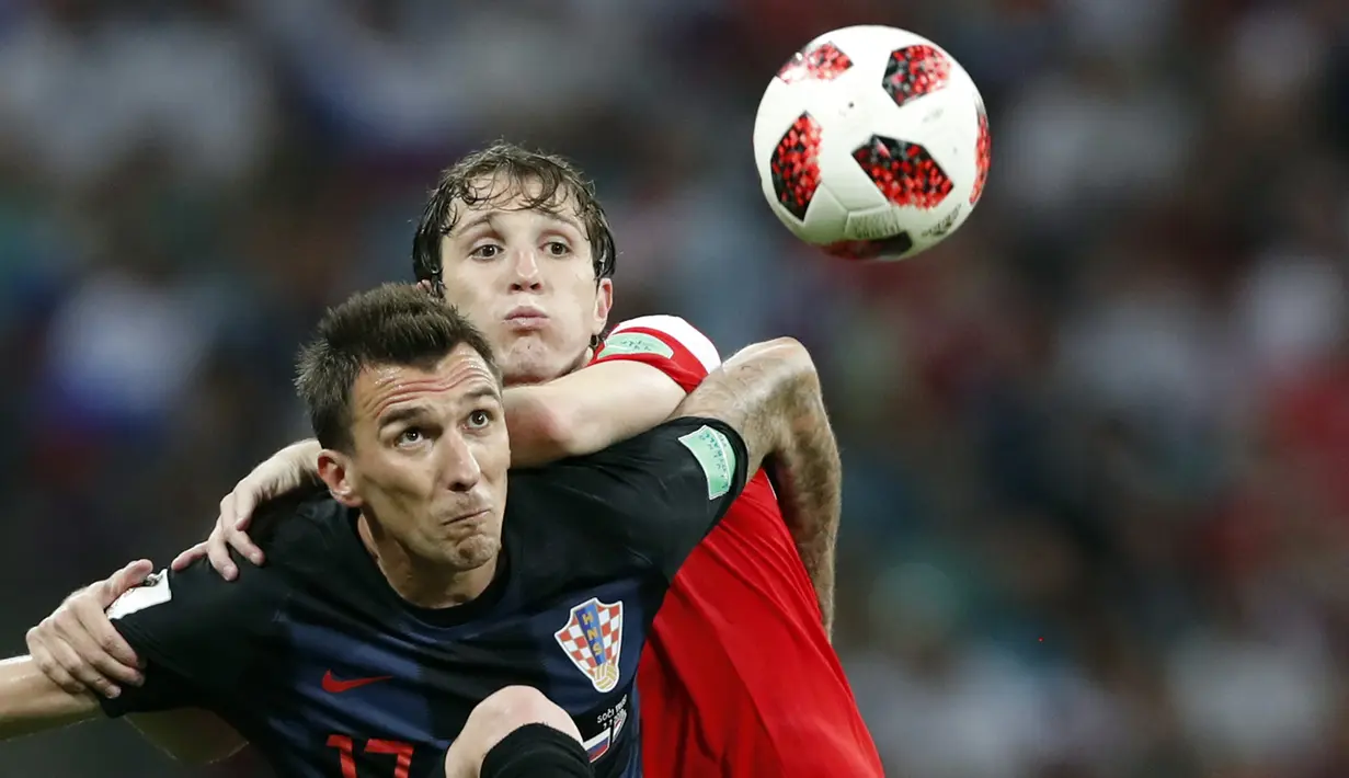 Striker Kroasia, Mario Mandzukic, berebut bola dengan bek Rusia, Mario Fernandes, pada laga perempat final Piala Dunia di Stadion Fisht, Sochi, Sabtu (7/7/2018). Kroasia menang 2-2 (4-3) atas Rusia. (AP/Rebecca Blackwell)