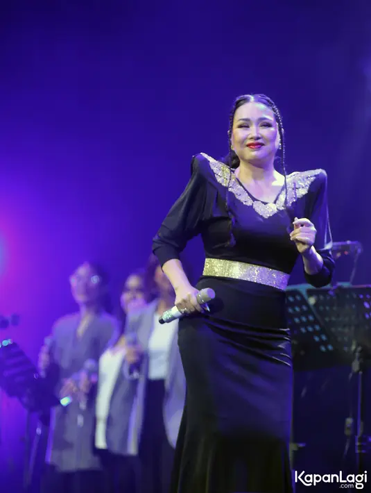 Titi Dj turut tampil menyanyikan Sang Dewi kenakan long dress dengan aksen emas di leher dan pinggang. [Foto: KLY/Adrian Utama Putra].