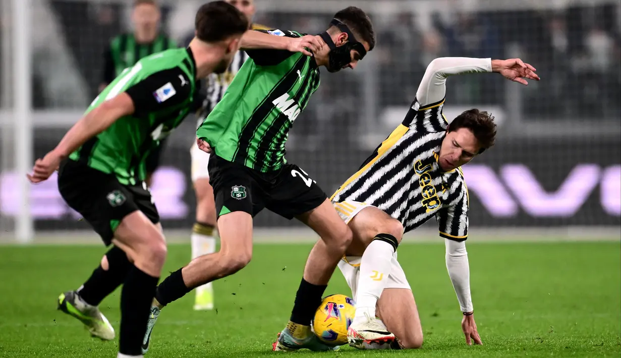 Pemain Juventus, Federico Chiesa, berebut bola dengan pemain Sassuolo, Daniel Boloca, dalam laga Serie A 2023/2024 giornata 20 yang dihelat di Allianz Stadium, Rabu (17/1/2024). (AFP/Marco Bertorello)