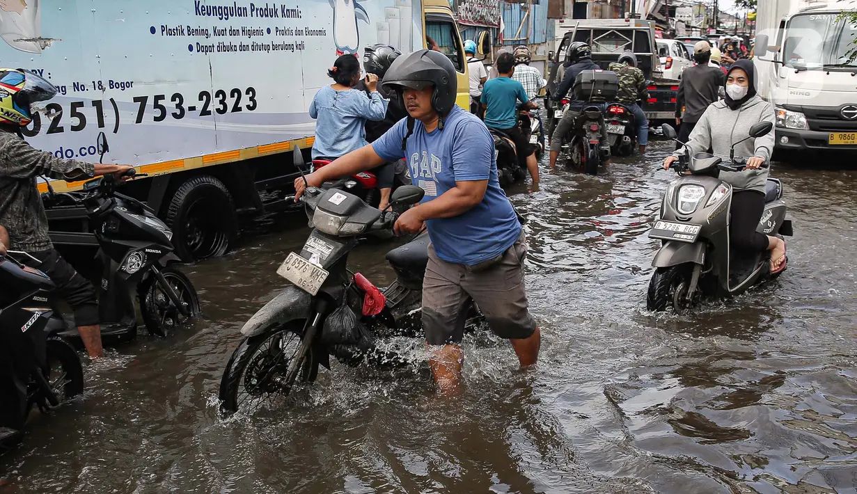 Sejumlah kendaraan menerobos banjir yang menggenangi jalan raya Kamal, Cengkareng, Jakarta Barat, Kamis (30/1/2025). (Liputan6.com/Angga Yuniar)