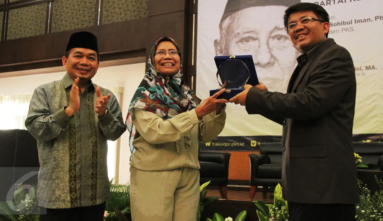Presiden PKS Mohamad Sohibul Iman bersama Ketua Fraksi PKS DPR Jazuli Juwaini memberikan plakat kepada putri Kasman Singodimedjo, Prof Dr drg Dewi Nurul Istiqomah usai acara seminar dan buka puasa di Jakarta, Kamis (16/6). (Liputan6.com/Fery Pradolo) 