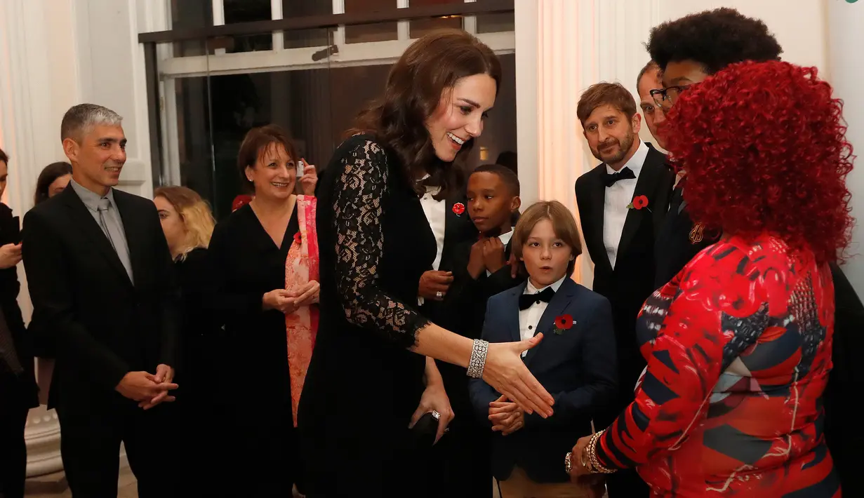 Kate Middleton menyapa tamu pada sebuah acara amal di Kensington Palace, London, Selasa (7/11). Meski kerap memakai baju koleksi lamanya, Kate selalu punya cara untuk membuat penampilannya terlihat lebih fresh dan berbeda. (AP/Frank Augstein, pool)