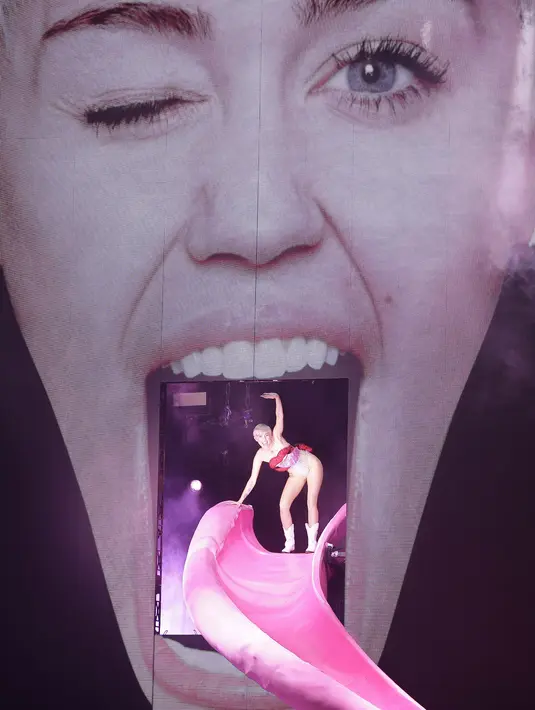 Miley Cyrus siap beraksi kembali, dengan kostum seksinya ia menyapa penonton dari panggung berbentuk wajahnya yang sedang menjulurkan lidah. (Bintang/EPA)