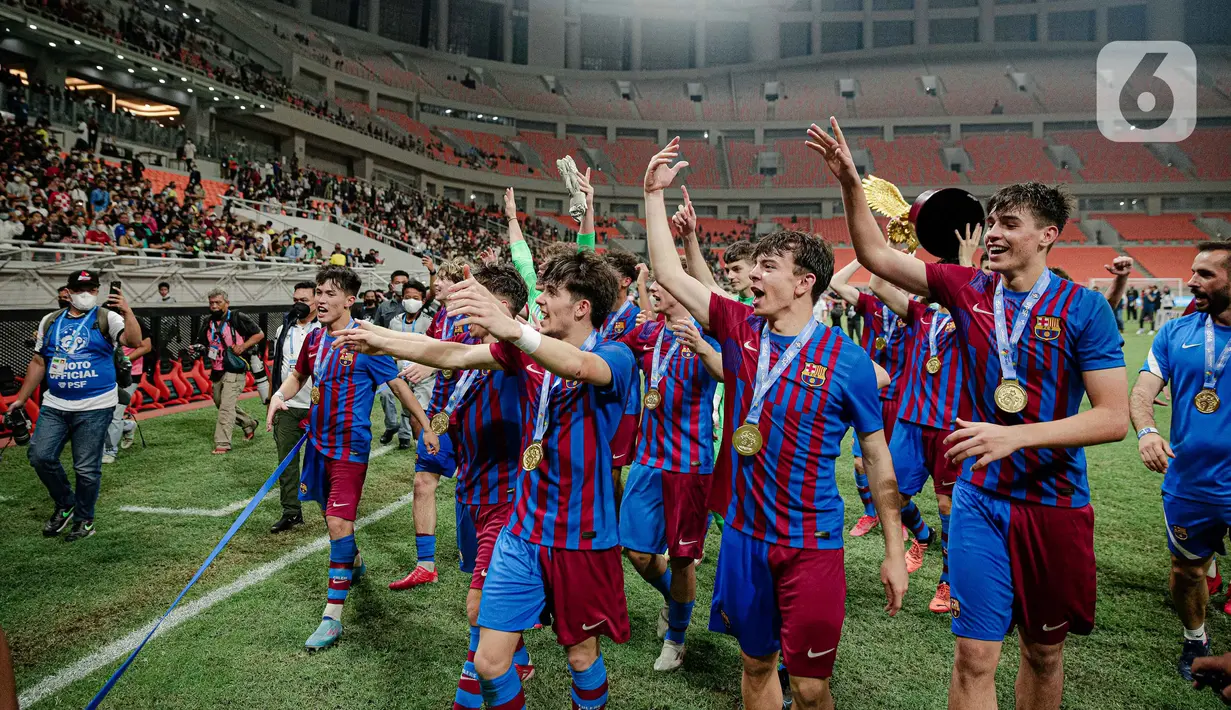 Para pemain Barcelona U-18 menyapa fans usai menjadi juara International Youth Championship (IYC) 2021 di Jakarta International Stadium (JIS), Jakarta, Selasa (19/4/2022). Barcelona U-18 juara IYC 2021 usai menang atas Altetico Madrid U-18. (Liputan6.com/Faizal Fanani)