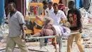 Petugas membawa korban dari serangan bom mobil di Mogadishu, Somalia, Rabu (25/1). Orang-orang yang terluka saat ini dilaporkan tengah mendapat perawatan di rumah sakit Hayad, yang terdekat dengan lokasi kejadian. (AP Photo)