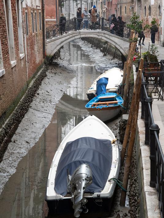 Kapal berlabuh di sepanjang kanal kering saat air surut di Venesia, Italia, 21 Februari 2023. Sungai-sungai dan danau-danau di Italia menderita kekurangan air yang parah, kata kelompok lingkungan Legambiente, dengan perhatian terfokus pada bagian utara negara itu. (AP Photo/Luigi Costantini)