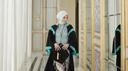 Kebaya biru Ansel dipadukan dengan kain batik dengan perpaaduan warna putih, cokelat muda, dan cokelat tua. Pakai atribut wisuda lengkap mulai dari jubah, toga dan medali, kebahagiaan terpancar jelas di wajah Ansellma Putri. Berpose candid sembari jalan, foto Ansellma ini dijepret dengan apik oleh fotografer. Lewat keterangan unggahannya, Ansel butuh dua hari untuk memilih foto. (Liputan6.com/IG/@ansellmaputri)