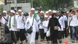 Peserta demo 2 Desember terlihat masih berjalan menuju Monas dari arah Tanah Abang, Jakarta, Jumat (2/12). Tidak hanya kaum pria, tampak kaum perempuan juga turut dalam aksi doa bersama di Monas. (Liputan6.com/Helmi Afandi)