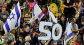 Seorang demonstran memegang angka "50", yang merujuk pada jumlah sandera yang masih berada di Jalur Gaza sejak serangan 7 Oktober 2023 oleh milisi Hamas, selama protes anti-pemerintah di luar markas besar Kementerian Pertahanan Israel di Tel Aviv pada 28 Juni 2025. (Jack GUEZ/AFP)