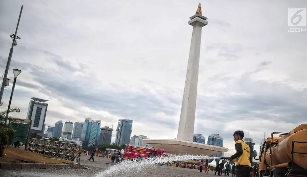 Petugas kebersihan membersihkan sisa sampah usai perayaan Tahun Baru 2019 di Monas, Jakarta, Selasa (1/1). Gubernur DKI Jakarta Anies Baswedan menyebutkan bahwa total sampah yang ada di Monas mencapai 45 ton. (Liputan6.com/Faizal Fanani)