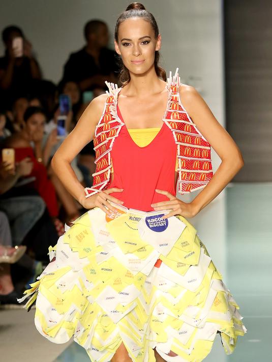 Model berpose di atas runaway memakai koleksi yang diberi nama McDCouture Collection dalam Miami Swim Week, 20 Juni 2017. Koleksi baju renang tersebut dikreasikan dengan ribuan kemasan makanan cepat saji McDonald's. (ALEXANDER TAMARGO/GETTY IMAGES/AFP)