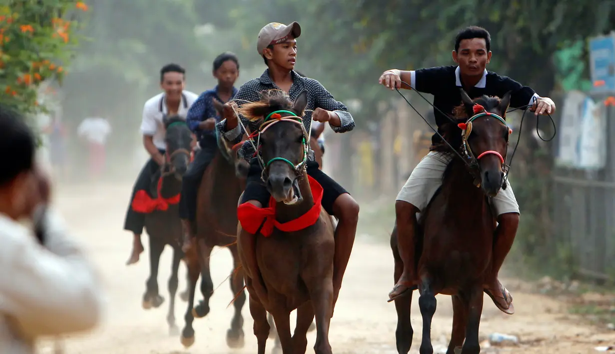 Penduduk lokal memacu kuda tunggangannya ketika mengikuti balapan dalam Festival Pchum Ben di provinsi Kandal, Kamboja, Rabu (20/9). Selain balapan kerbau juga diadakan balapan kuda dan pertandingan gulat tradisional. (AP Photo/Heng Sinith)