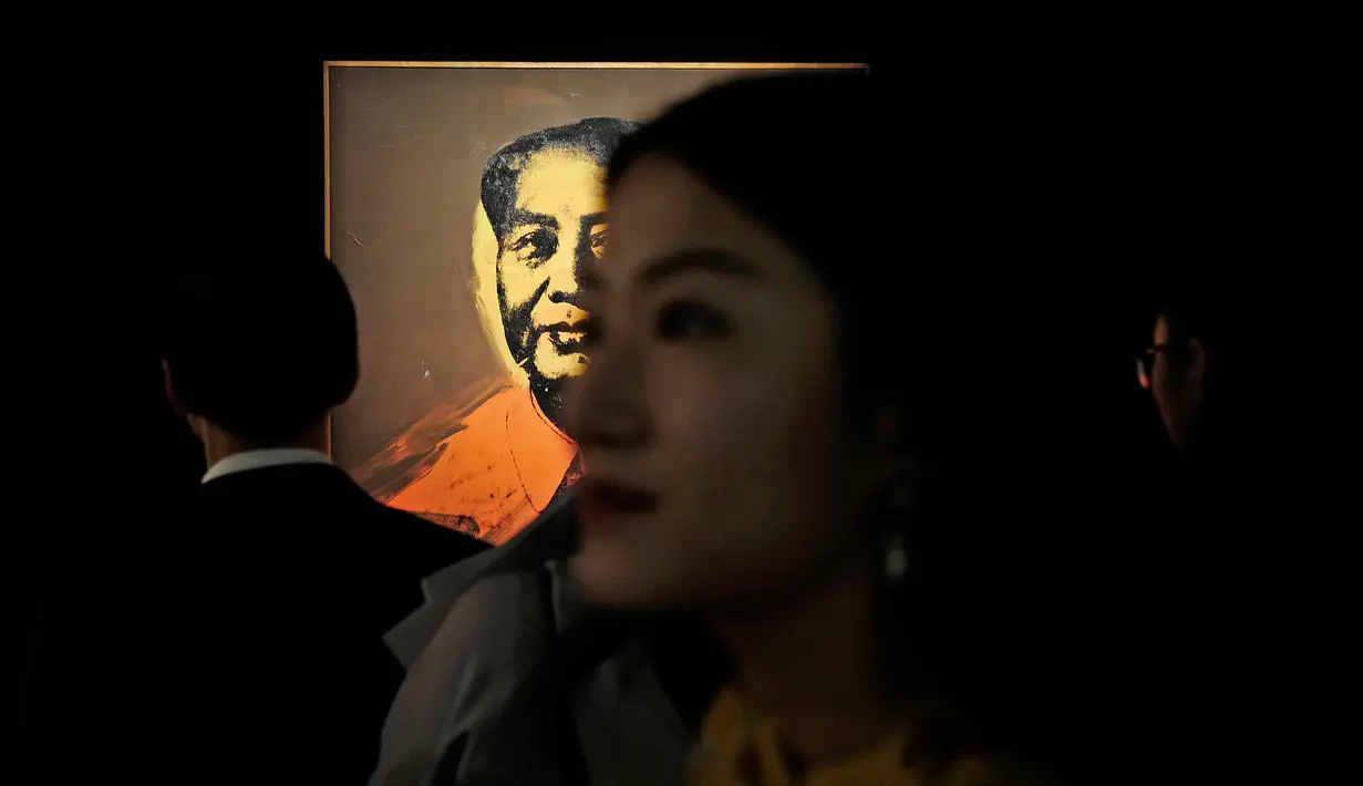 Pengunjung berdiri di dekat lukisan Mao Zedong karya seniman Andy Warhol selama Modern and Contemporary Art Evening Sale di Hongkong, Jumat (31/3). Lukisan ini diharapkan bisa laku seharga USD 15 juta (sekitar Rp 200 miliar). (AP Photo / Vincent Yu)