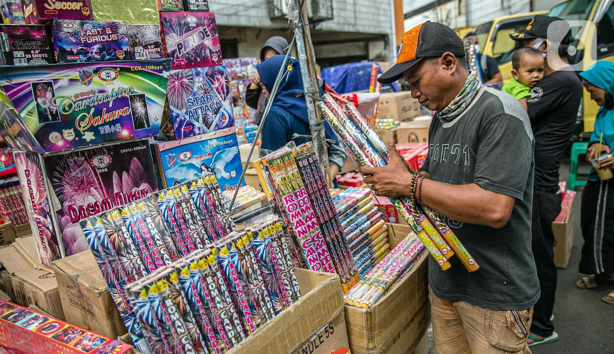 Seorang pedagang menata kembang api di Pasar Asemka, Jakarta, Selasa (29/12/2020). Sejumlah pedagang menyatakan, jelang perayaan Tahun Baru 2021 ini penjualan kembang api mengalami penurunan 75 persen dari tahun lalu. (Liputan6.com/Faizal Fanani)